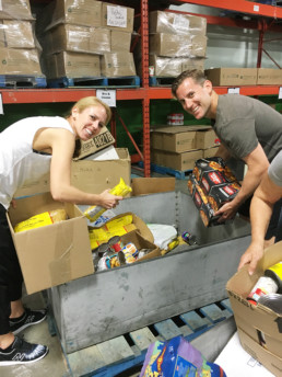 Man and Woman packing food hampers for the Edmonton Food Bank. The Melton Foundation Charity Work.